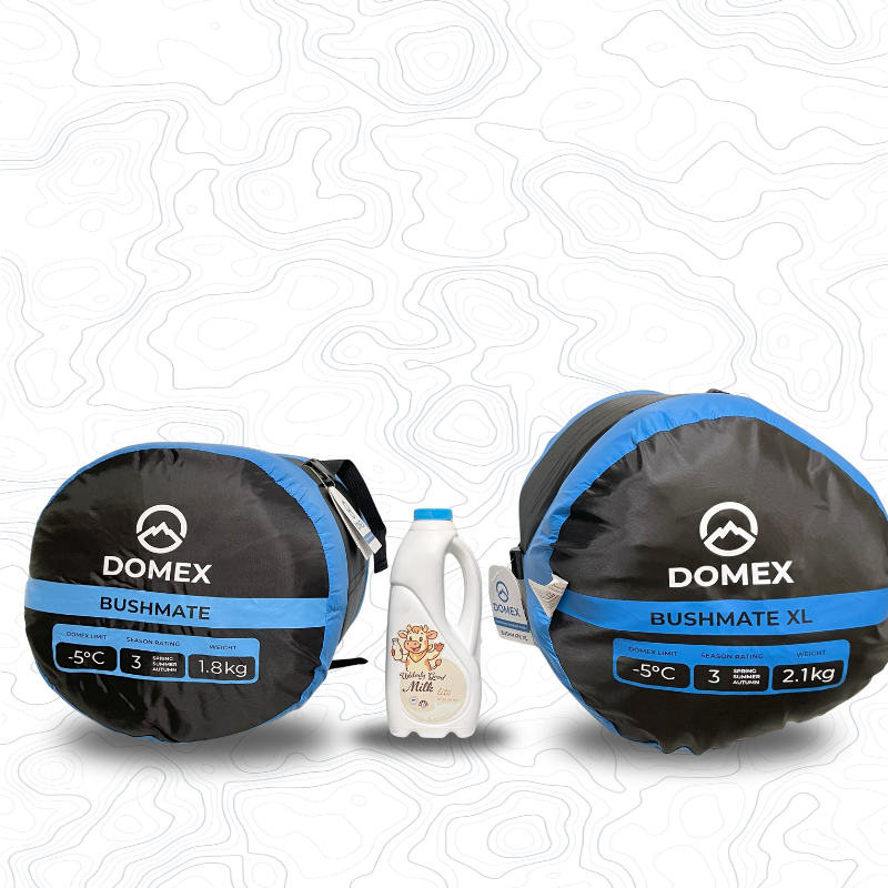Scale image of two Domex Bushmate Synthetic Sleeping Bags End On - Blue. On left is small -5C, 1.8kg, on right is XL--5C, 2.1kg. In between is 1L bottle of milk for comparison | GENERAL