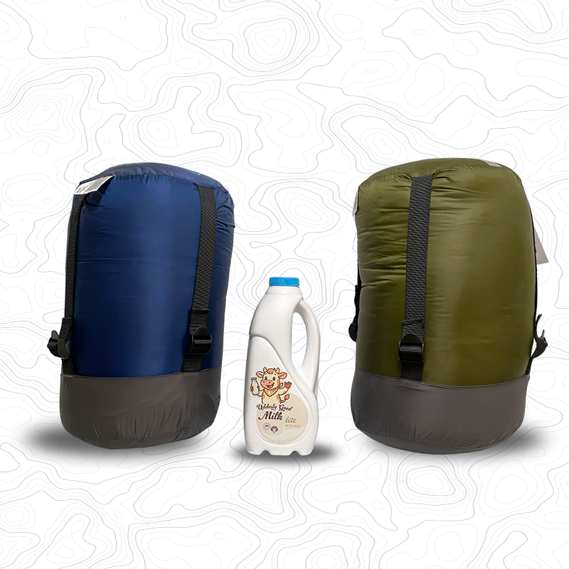 Image of compression sacks on end for Domex Venture Sleeping Bag (blue) and Venture XT Sleeping Bag (green) with a 1 litre bottle of milk between them for scale | GENERAL