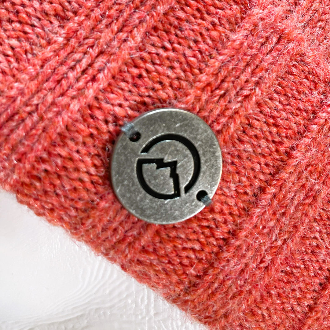 Close up of Domex Medallion on Pink thick rib-knit cuffed beanie